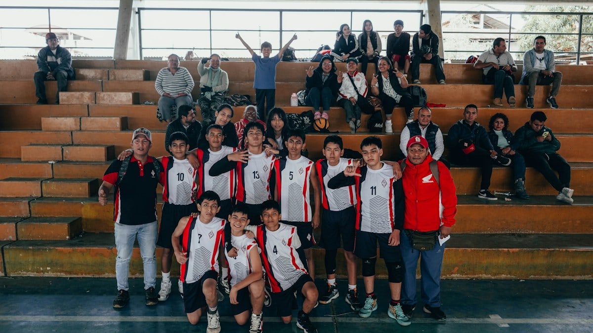A group of young men standing next to each other on a basketball court